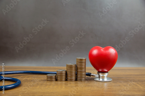 Coins stacked in a graph shape and heart with stethoscope. Concepts a physical examination for health care and medical insurance.