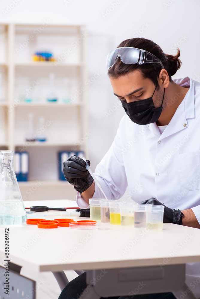 Young male chemist working in the lab Young male chemist working in the lab