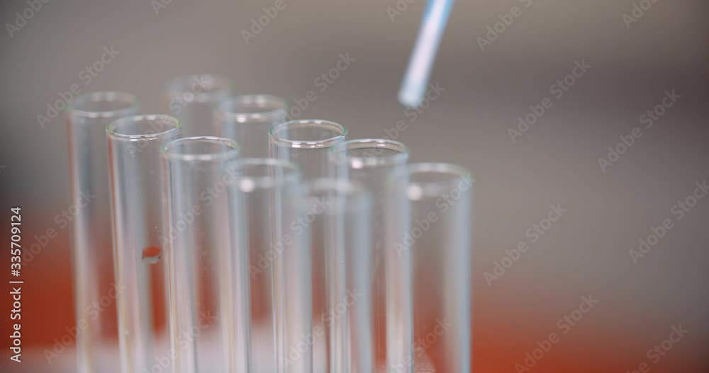 Extreme Close up of Pipette Dropping Water into Sample Tube at Laboratory Extreme Close up of Pipette Dropping Water into Sample Tube at Laboratory