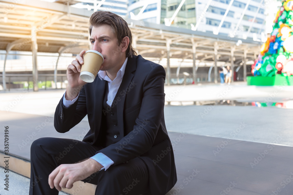 Handsome businessman taking a break and drinking hot coffee in city. Caucasian guy wear suit, white shirt. Attractive handsome men holding paper cup of coffee. He love drinking coffee, get freshness Handsome businessman taking a break and drinking hot coffee in city. Caucasian guy wear suit, white shirt. Attractive handsome men holding paper cup of coffee. He love drinking coffee, get freshness
