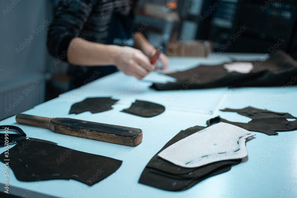 man shaping leather for shoe with knife on factory man shaping leather for shoe with knife on factory
