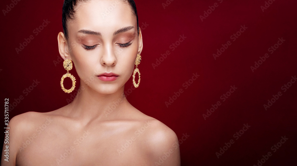 close-up beauty portrait fashion model, clean skin, red background, gold earrings, hairstyle high bun, art creative fashion photography, copy space place for text close-up beauty portrait fashion model, clean skin, red background, gold earrings, hairstyle high bun, art creative fashion photography, copy space place for text