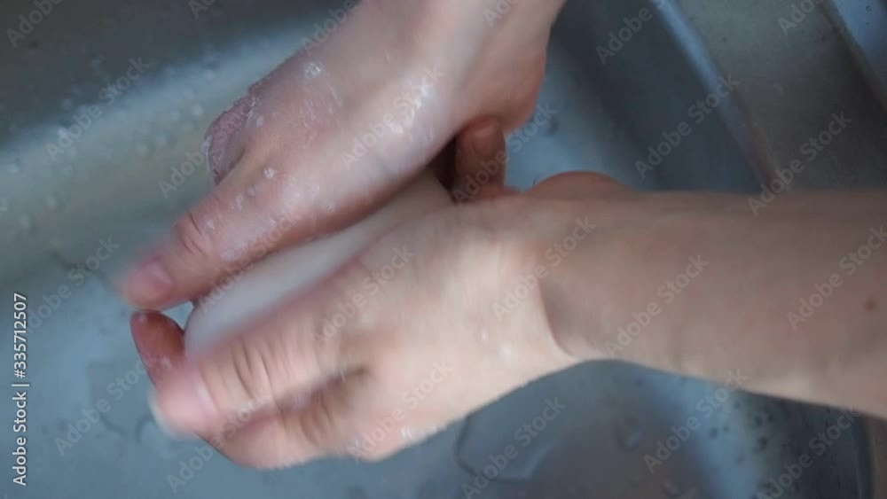 woman holds soap in her hand over the sink. concept treating the skin of hands from viruses and microbes woman holds soap in her hand over the sink. concept treating the skin of hands from viruses and microbes