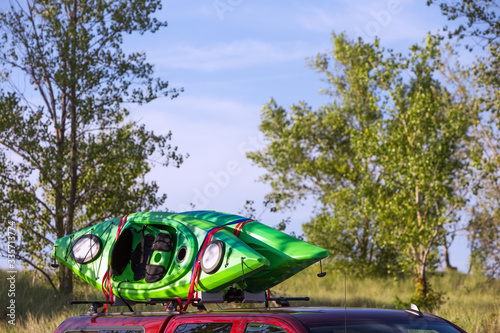 Two kayaks tied to the top of vehicle in a wilderness area