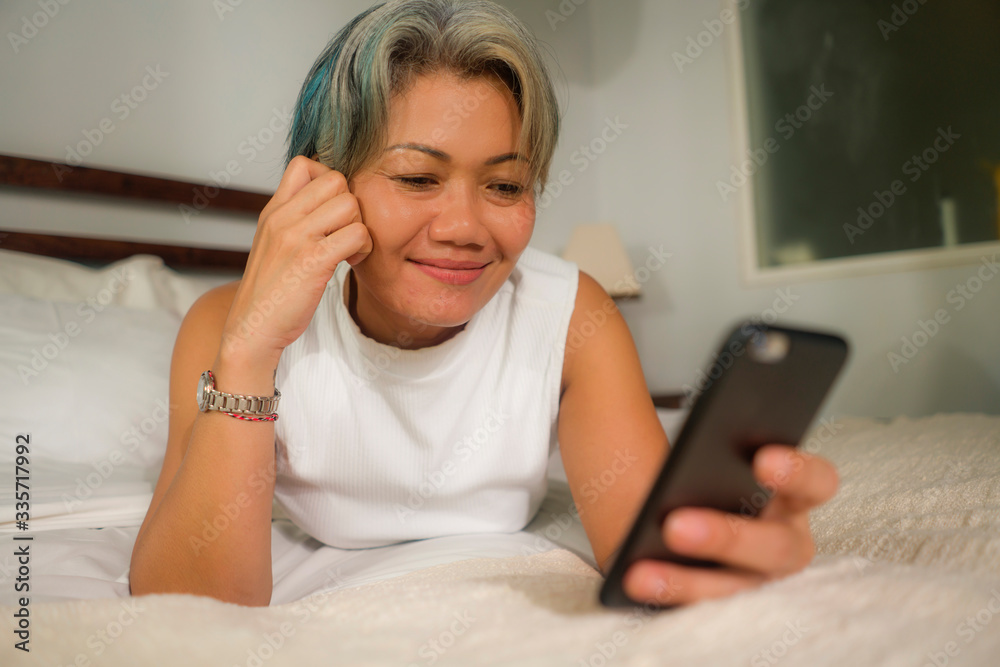 home lifestyle portrait of attractive and happy middle aged woman on her 50s using internet mobile phone in bed relaxed and cheerful online dating or enjoying social media app home lifestyle portrait of attractive and happy middle aged woman on her 50s using internet mobile phone in bed relaxed and cheerful online dating or enjoying social media app