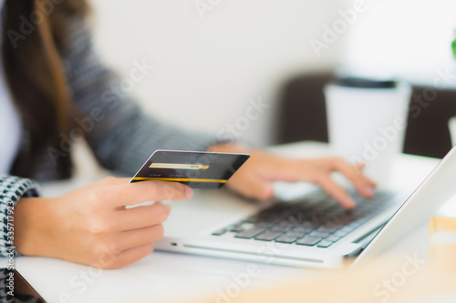 Portrait beautiful young asian woman use credit card with laptop for online shopping