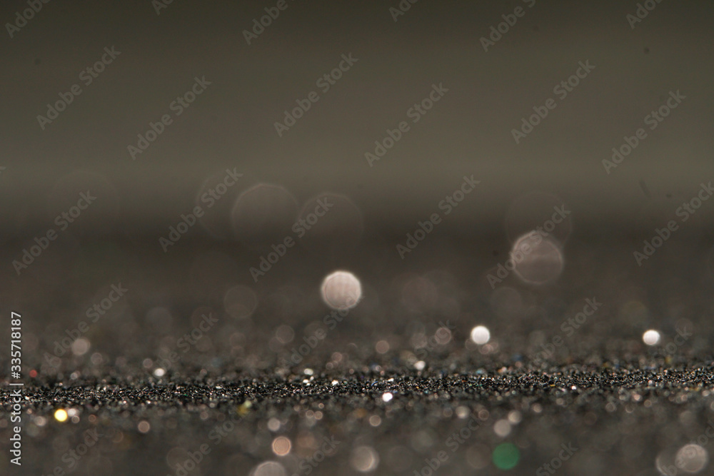 Fototapeta premium silver Sparkling Lights Festive background with texture. Abstract Christmas twinkled bright bokeh defocused and Falling stars. Winter Card or invitation.