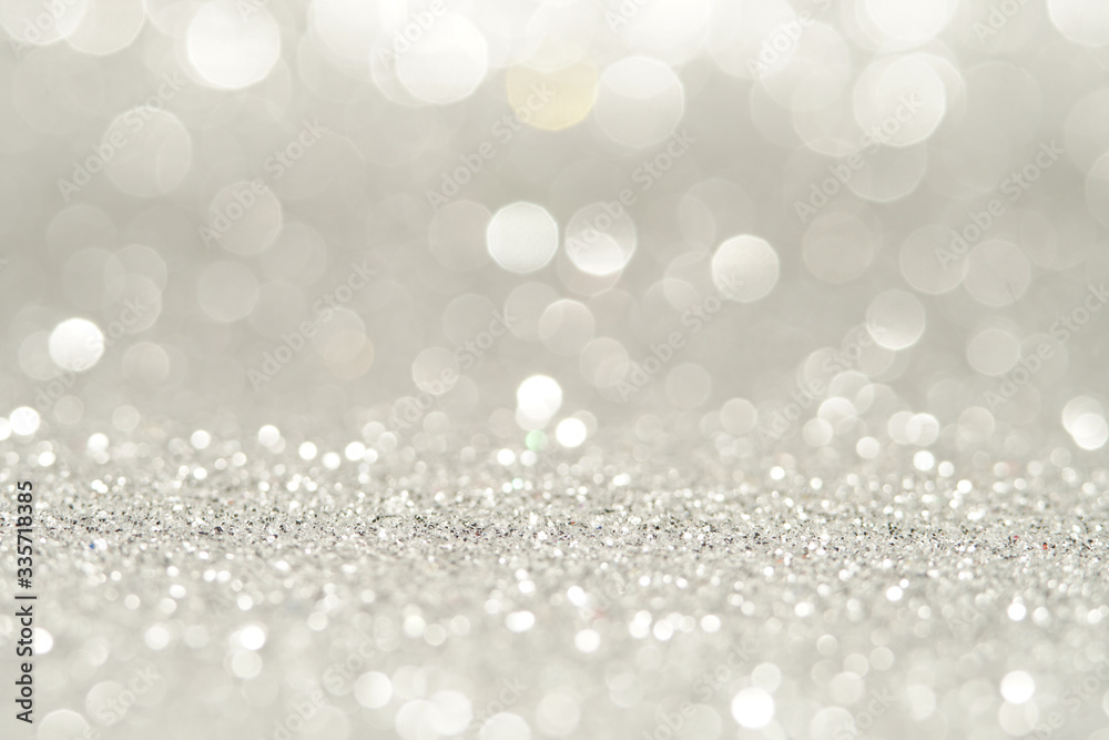 silver Sparkling Lights Festive background with texture. Abstract Christmas twinkled bright bokeh defocused and Falling stars. Winter Card or invitation.