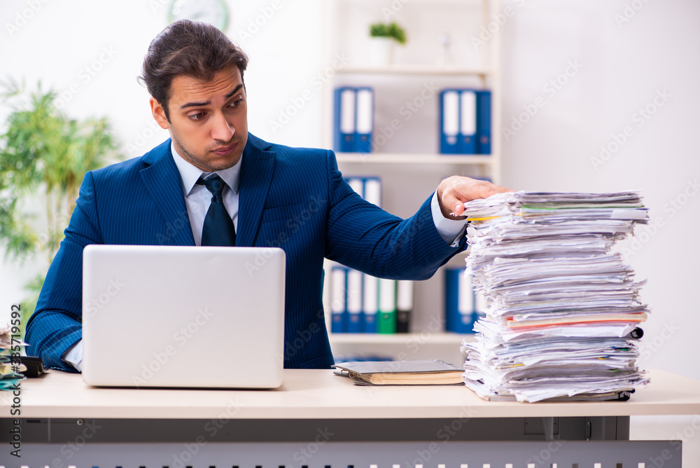 Young male employee unhappy with excessive work Young male employee unhappy with excessive work