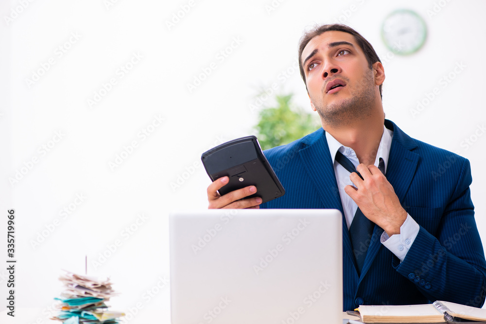 Young male employee unhappy with excessive work Young male employee unhappy with excessive work