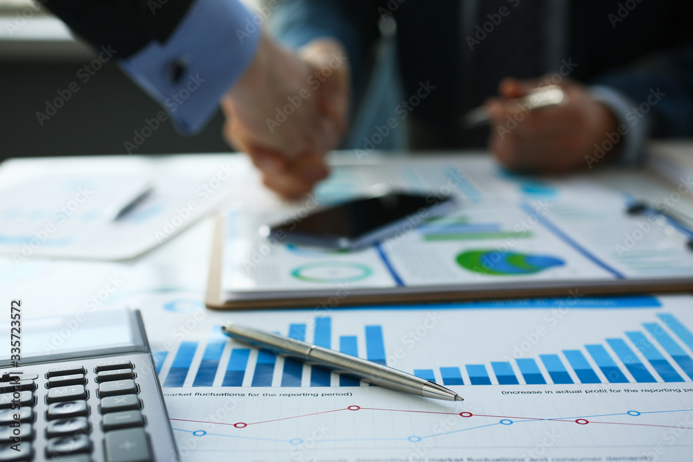 Businessman in sut hand shake in ofiice closeup. Introduce manager job man risk chart paper how deal teamwork agency employment complite finish paperwork concept Businessman in sut hand shake in ofiice closeup. Introduce manager job man risk chart paper how deal teamwork agency employment complite finish paperwork concept