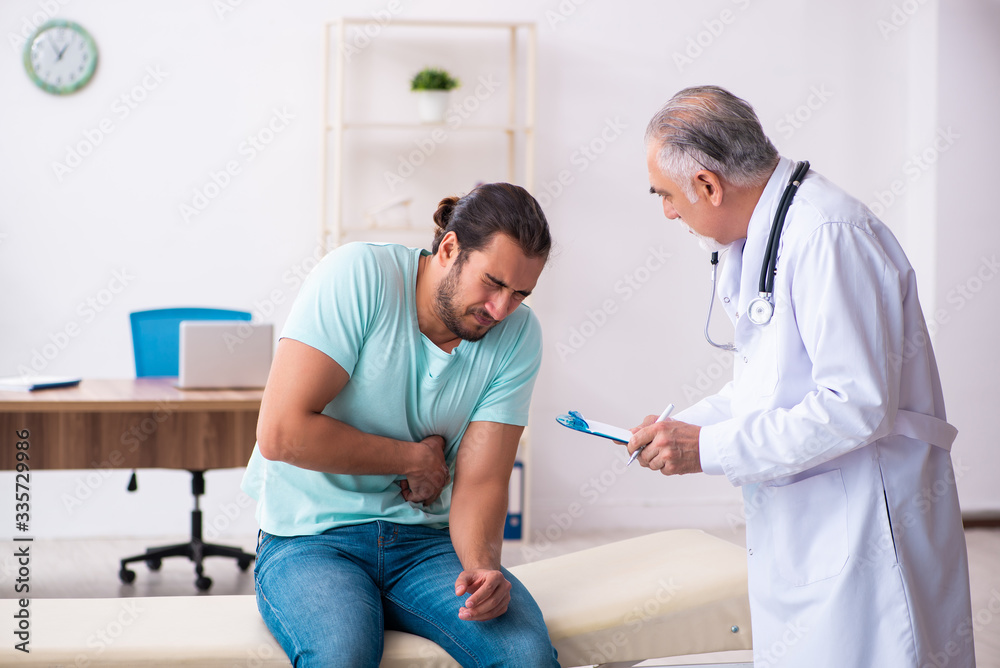 Fototapeta premium Injured young man visiting old doctor