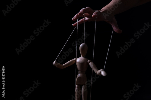 Fotomurale Conceptual image of a hand with strings to control a marionette