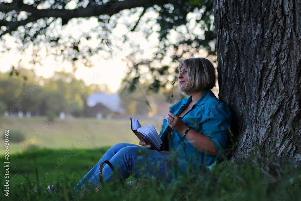 woman in the park tree reading book woman in the park tree reading book