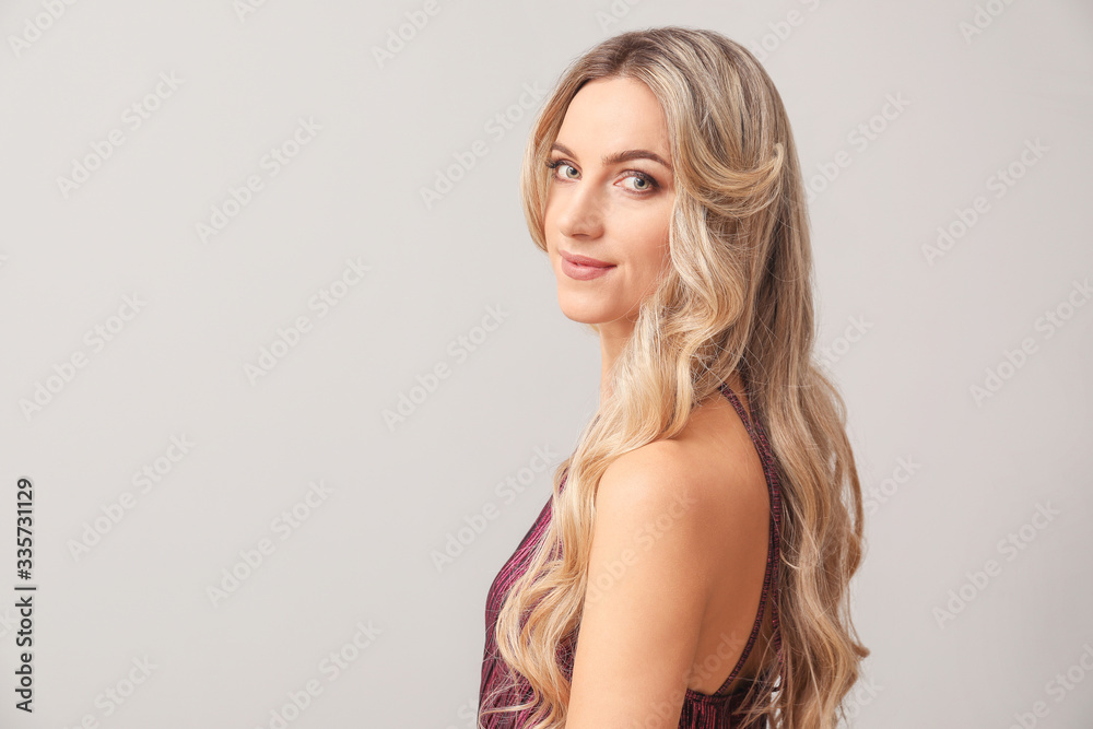 Beautiful young woman with curly hair on light background Beautiful young woman with curly hair on light background