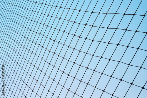 Football protection net on bright blue sky background