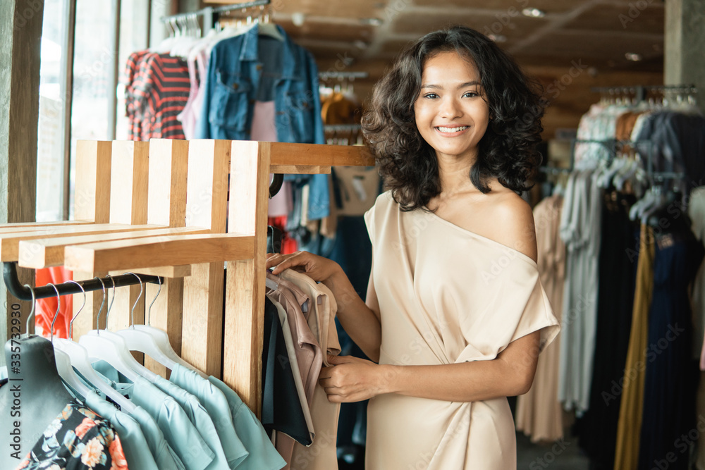 beautiful young asian fashion shop owner at her boutique standing proudly and smile to camera