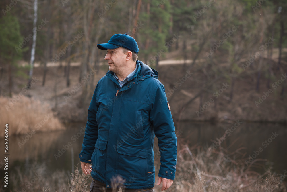 Mature man rest at nature in forest and lake, senior man lifestyle