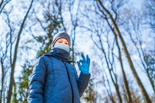 Boy in medical rubber gloves and mask. Boy shows ok sign in front of camera. Stop the coronavirus. Pandemic. COVID-19, corona virus epidemic, infection, quarantine, virus. photo