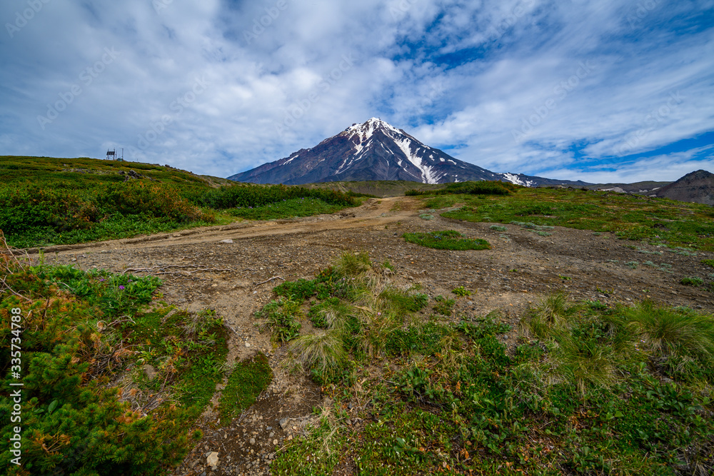 Fototapeta premium Panoramic view of the city Petropavlovsk-Kamchatsky and volcanoes: Koryaksky Volcano, Avacha Volcano, Kozelsky Volcano. Russian Far East, Kamchatka Peninsula.