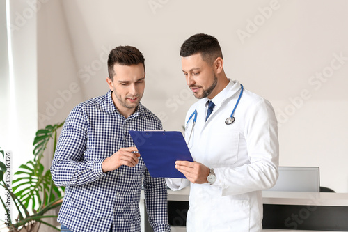 Male doctor with patient wo...