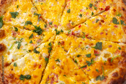 A closeup view of a breakfast pizza pie, as a background.