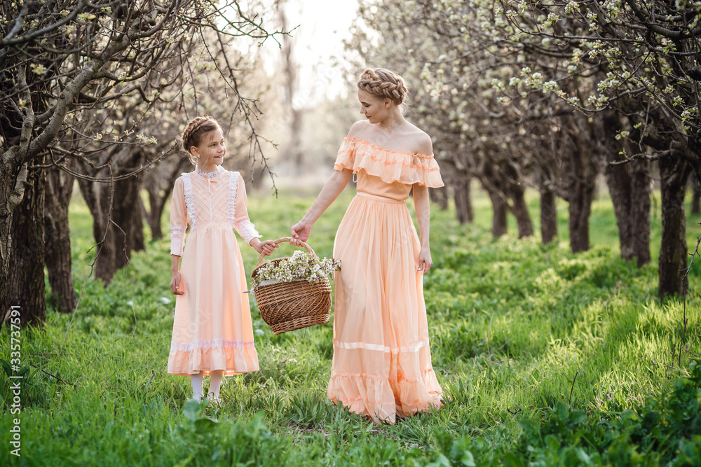Two sisters are walking in the garden, - obrazy, fototapety, plakaty 