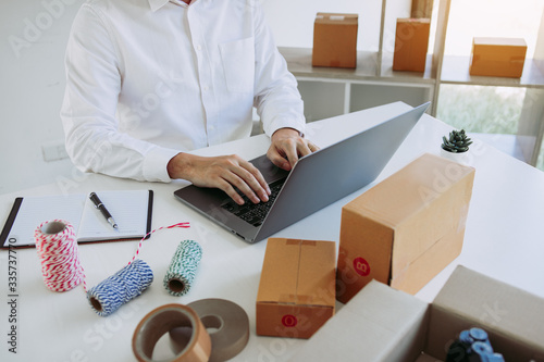 Entrepreneurs are working on taking orders of customers products by typing information tpying keyboard laptop computer in office room. photo