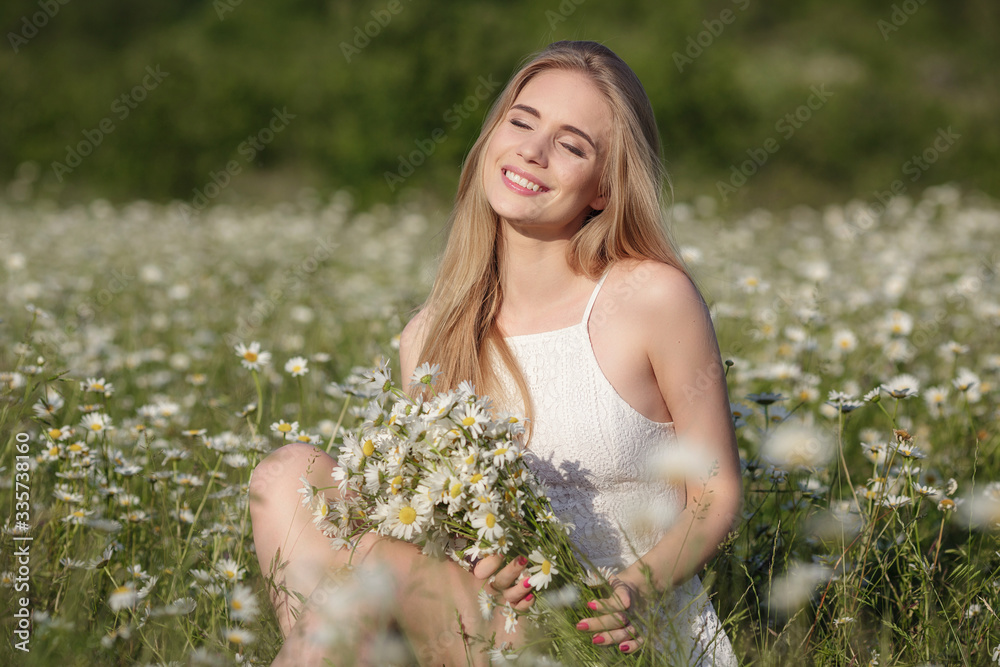 beautiful young woman in a camomile field in a picturesque valley beautiful young woman in a camomile field in a picturesque valley