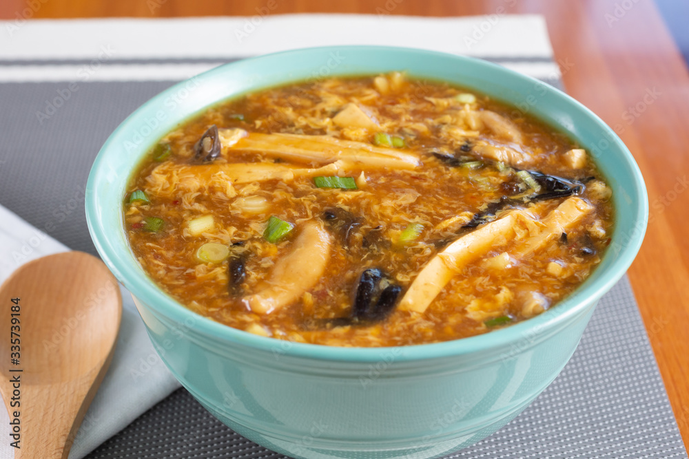 A view of a big bowl of Chinese hot and sour soup in a restaurant or kitchen setting. A view of a big bowl of Chinese hot and sour soup in a restaurant or kitchen setting.