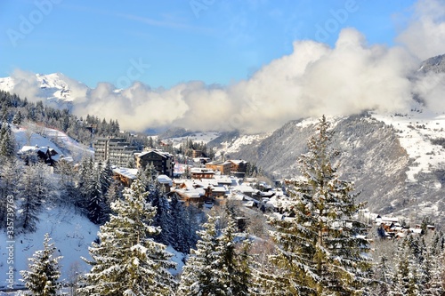 Ski resort village in Courchevel, Rhône Alps France in winter with beautiful chalets under clouds 