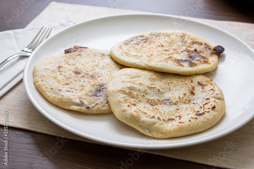 A view of a plate of pupusas in a restaurant or kitchen setting.
