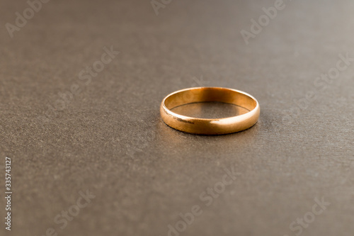 Wedding ring on a gray background. Symbol of loneliness and unrequited love. Concept.