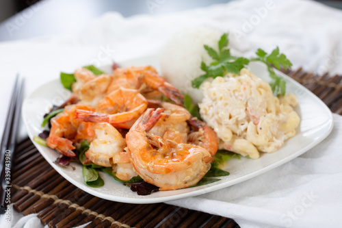 A view of a plate of garlic prawns, in a restaurant or kitchen setting.