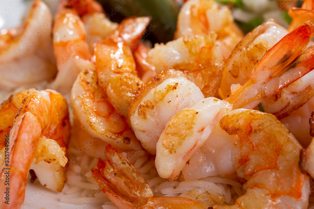 A closeup view of several cooked butterfly cut shrimp. A closeup view of several cooked butterfly cut shrimp.