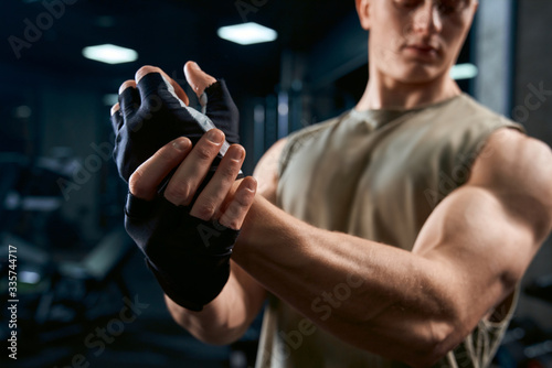 Bodybuilder stretching upper body in gym.