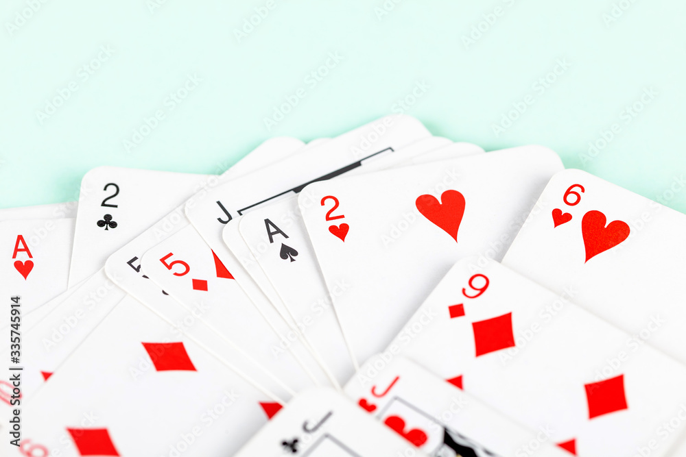 A big pile of tiny small scattered playing cards, macro, closeup, deck. Heap of mini cards face up abstract blue background texture. Card games, gambling, magic tricks and leisure simple concept