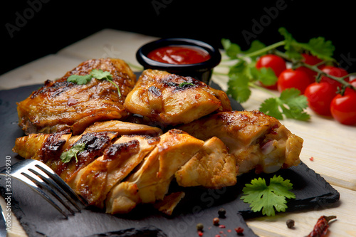 Photos grilled chicken with barbecue sauce on a wooden background