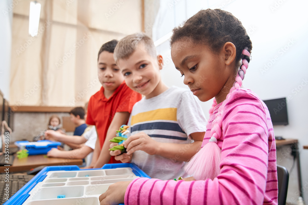 Fototapeta premium Kids using building kit to create toys.