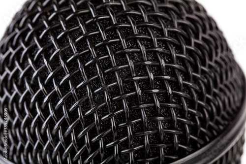 Metal black microphone grill macro, extreme closeup, reflective surface simple background texture, backdrop. Recording vocals, vocal training abstract concept, modern musical equipment up close © Tomasz