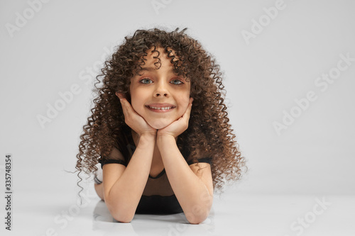 Little female gymnast posing on studio floor.