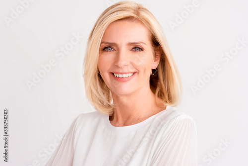 Portrait of attractive blond haired mature woman standing indoor