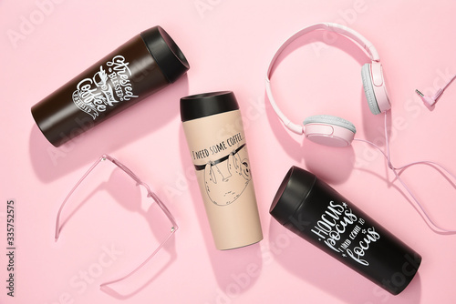 Obraz na płótnie Set of portable travel mugs, headphones and sunglasses on pink background