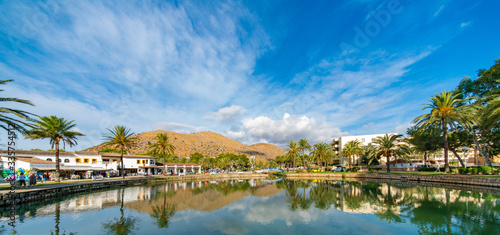 Lake in the park and palm trees around with mountains on the horizon