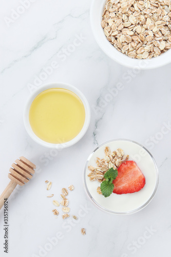 a cup of yogurt and strawberries on the table
