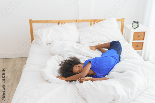 African girl is lying on bed.