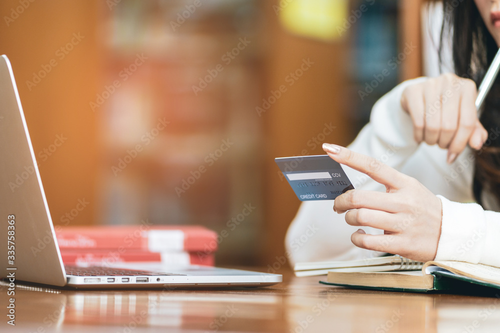 Young asian woman holding credit card and enter the payment code for the product with using laptop computer at home. Online shopping concept.woman dreams about purchasing through the internet Young asian woman holding credit card and enter the payment code for the product with using laptop computer at home. Online shopping concept.woman dreams about purchasing through the internet