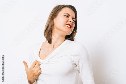 Close-up portrait of a young woman opening shirt to express that hot. Negative emotions, expressing, feeling