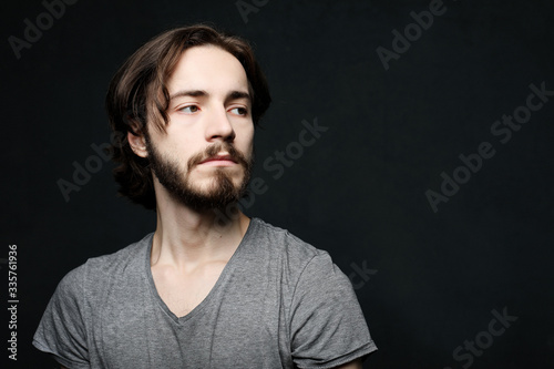 lifestyle and people concept: Portrait of handsome young bearded man on dark background