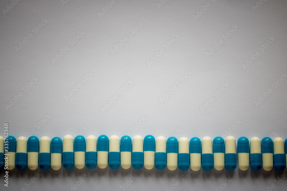 blue-white pills lined up against a plain background